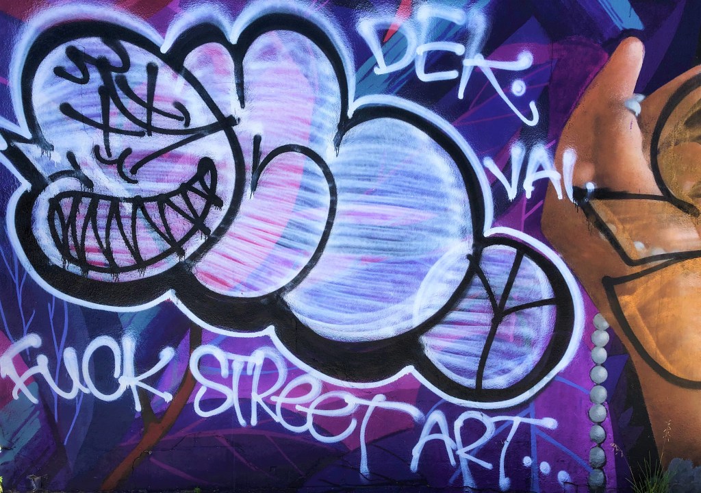 A graffiti covered wall

Description automatically generated